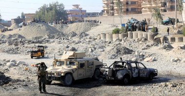 An Afghan National Army soldier inspects the wreckage of a burnt army car at the site of a blast in Jalalabad, Afghanistan, Jan. 28, 2021. (Reuters Photo)