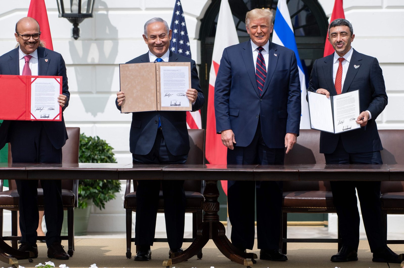(L-R) Bahrain Foreign Minister Abdullatif al-Zayani, Israeli Prime Minister Benjamin Netanyahu, U.S. President Donald Trump, and UAE Foreign Minister Abdullah bin Zayed Al-Nahyan hold up documents after participating in the signing of the Abraham Accords where Bahrain and UAE recognize Israel, at the White House in Washington, D.C., Sept. 15, 2020. (AFP Photo)