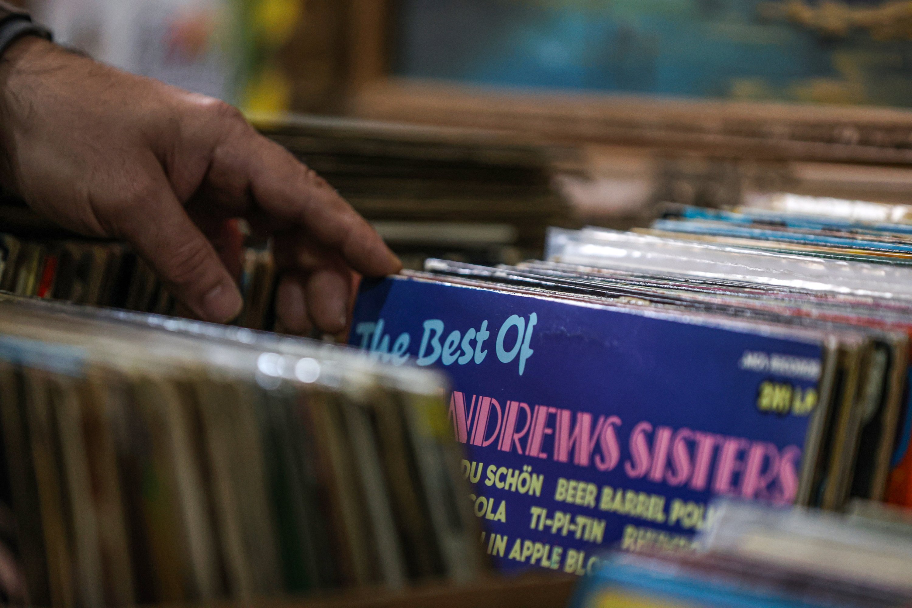 A man looks through vinyl records, where an album of the Andrews Sisters, an American close harmony singing group, is visible, Istanbul, Turkey, Jan. 28, 2021. (AA Photo)