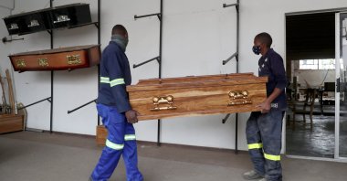 Workers carry a coffin to the display area at the Kingsize Coffins manufacturing plant, amid a nationwide coronavirus lockdown, in Benoni, South Africa, Jan. 25, 2021. (Reuters Photo)