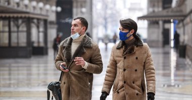 People smoke cigarettes in Galleria Vittorio Emanuele II in Milan on January 19, 2021 as it became the first Italian city to introduce an outdoor smoking ban following the air quality regulations approved by the Milan City Council. (AFP Photo)