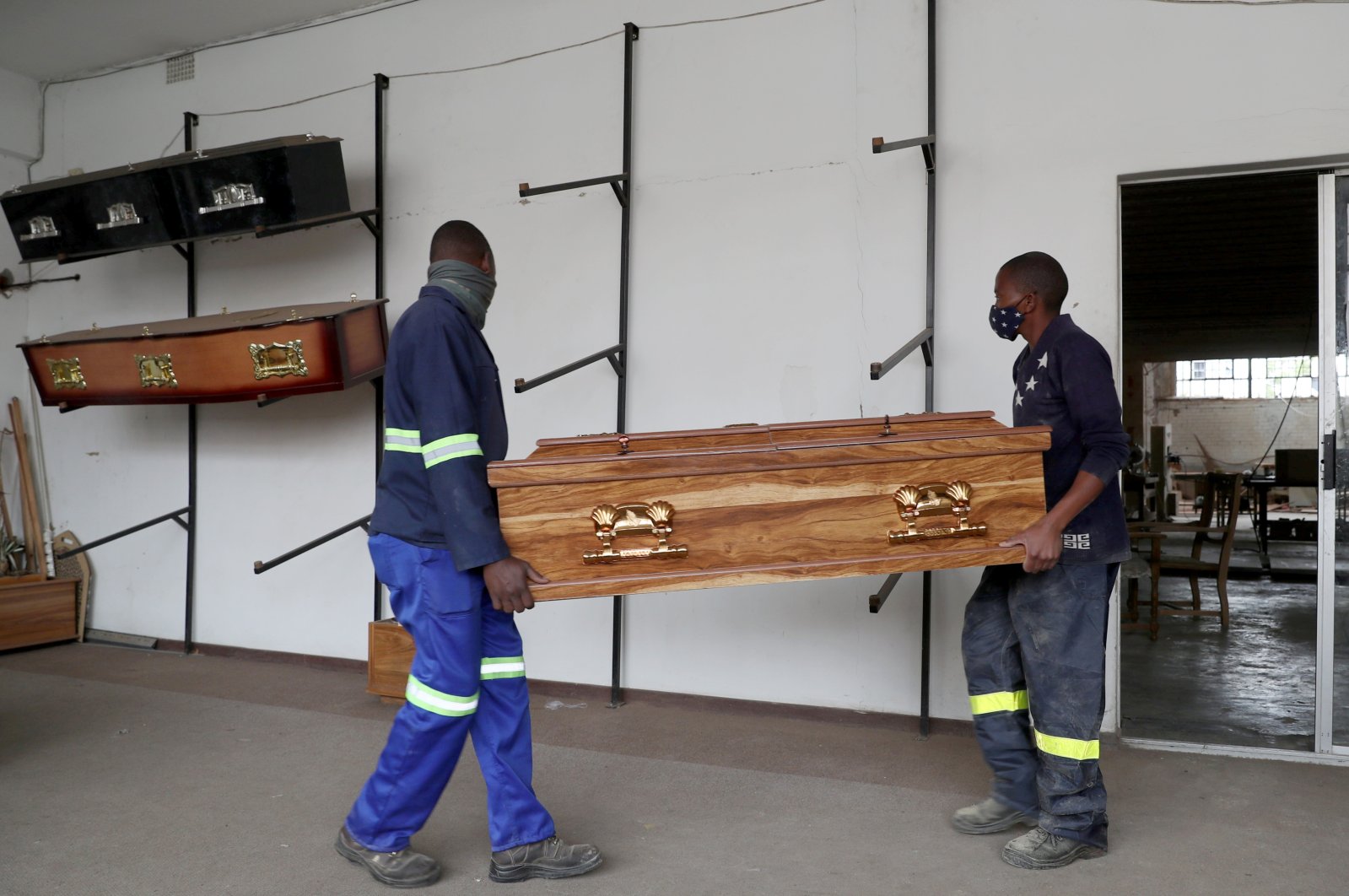 Workers carry a coffin to the display area at the Kingsize Coffins manufacturing plant, amid a nationwide coronavirus lockdown, in Benoni, South Africa, Jan. 25, 2021. (Reuters Photo)