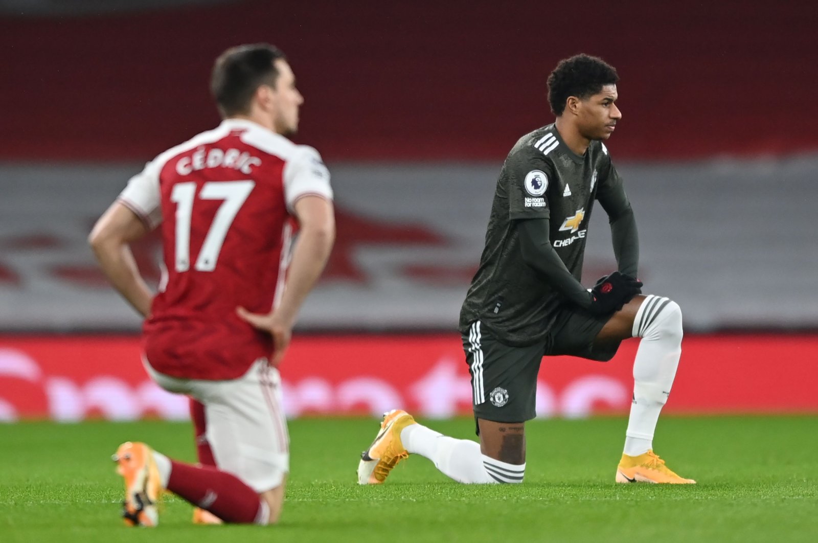Manchester United's English striker Marcus Rashford (R) 'takes a knee' in support of the No Room For Racism campaign ahead of the Premier League match against Arsenal at the Emirates Stadium, London, Jan. 30, 2021. (AFP Photo)