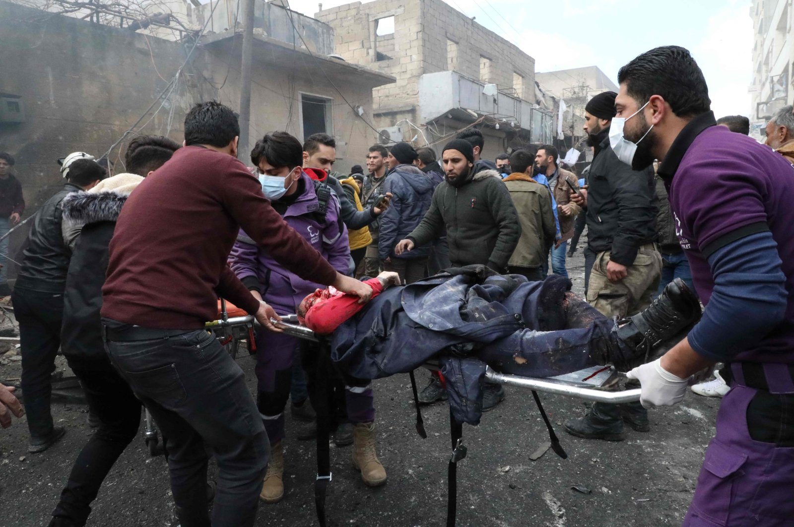 Rescue workers carry away a victim at the scene of an explosion in the town of Azaz in the opposition-controlled northern countryside of Syria's Aleppo province, on Jan. 31, 2021. (AFP)