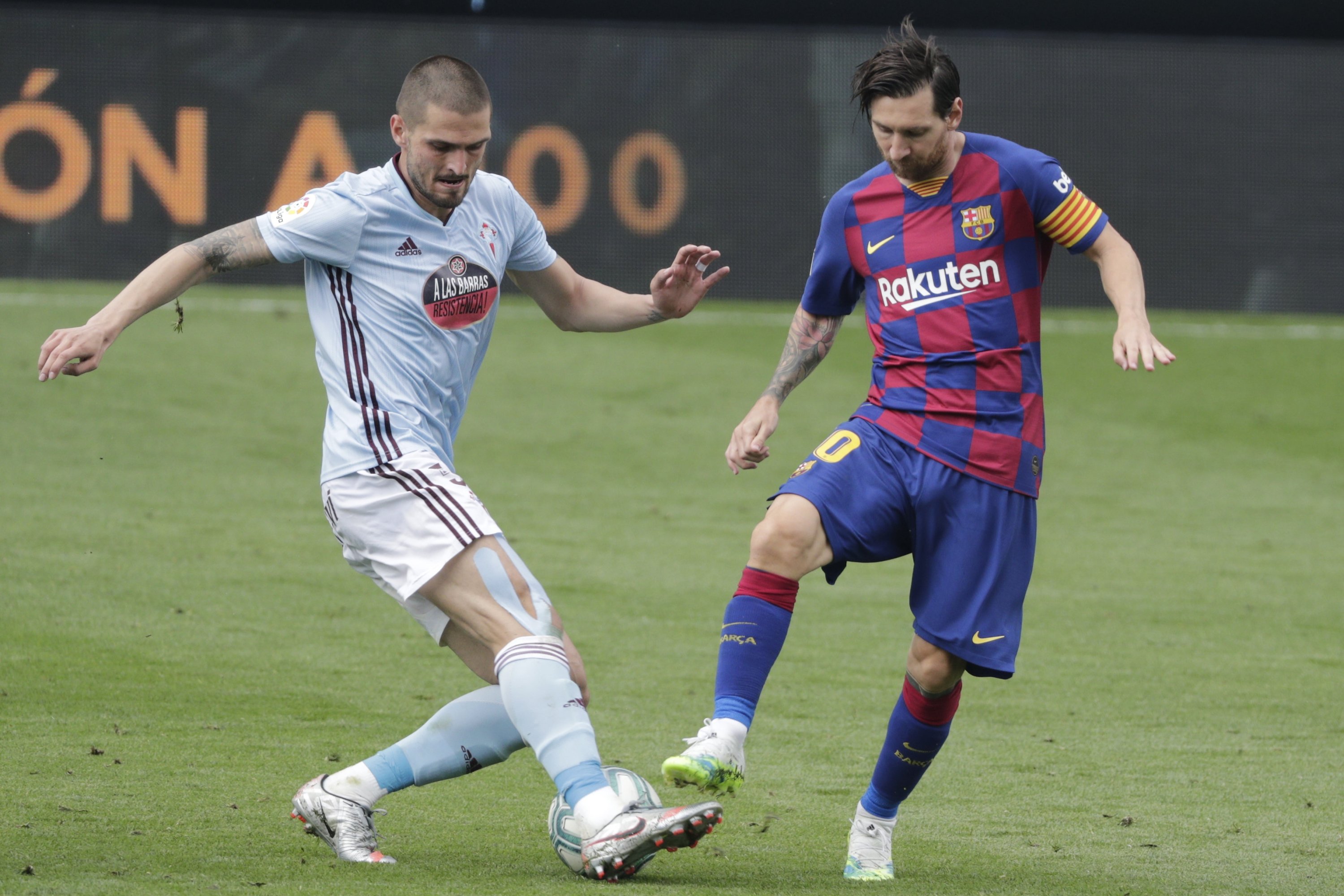 Celta Vigo's Turkish midfielder Okay Yokuşlu (L) in action against Barcelona's Lionel Messi at the Balaidos stadium in Vigo, Spain, Saturday, June 27, 2020. (AP Photo)