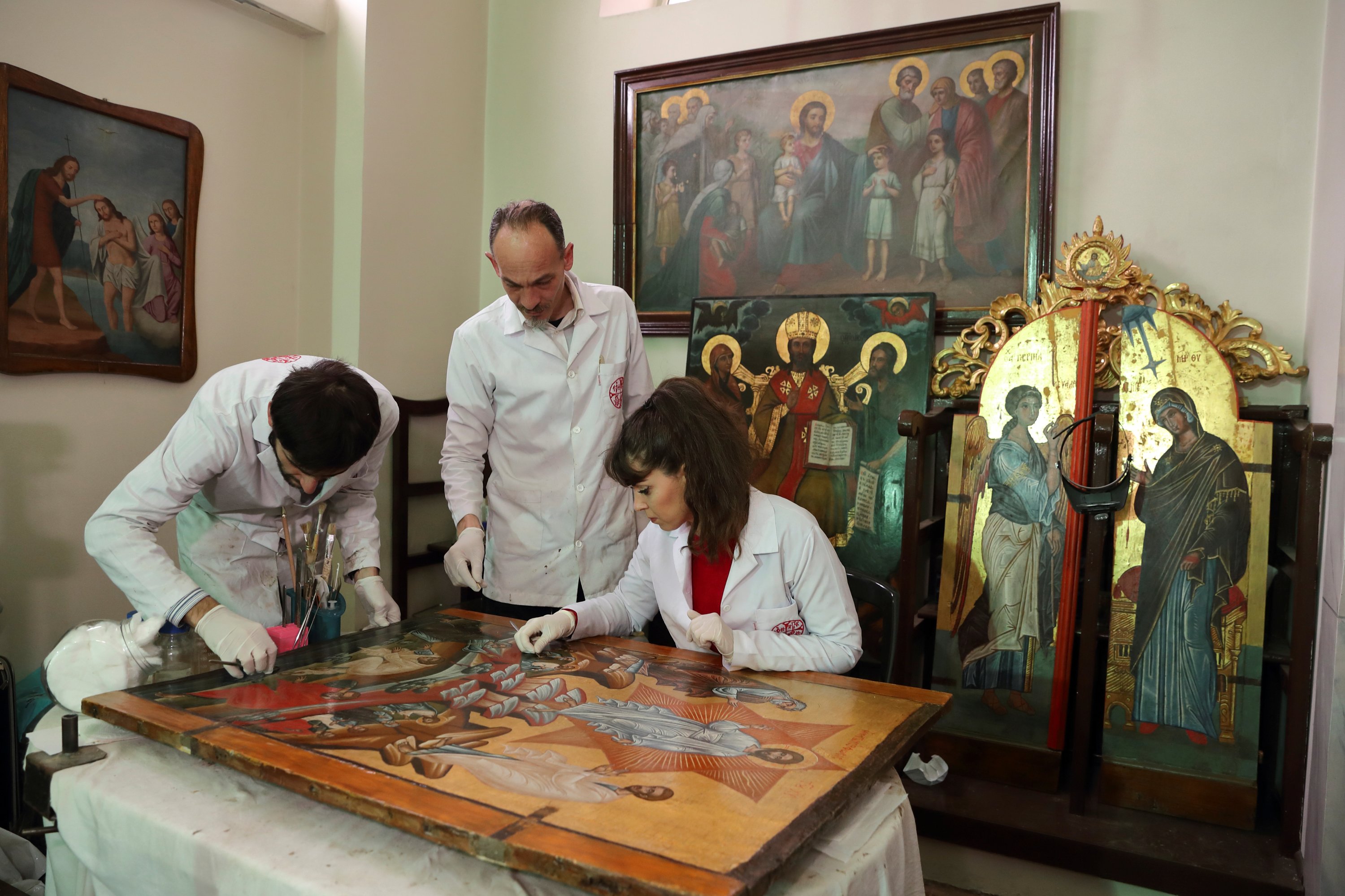  Venizelos Gavrilakis (C) accompanied by his assistants Umut Ballıkaya and Aslı Erel, works to clean and restore a 16th century zantine Christian icon at a Greek Orthodox church where Gavrilakis set up his laboratory in Istanbul, Turkey Jan. 26, 2021. (Reuters photo)