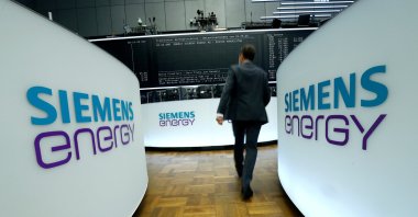 A trader walks next to Siemens Energy AG logos during Siemens Energy's initial public offering (IPO) at the Frankfurt Stock Exchange in Frankfurt, Germany, Sept., 28, 2020. (Reuters Photo)