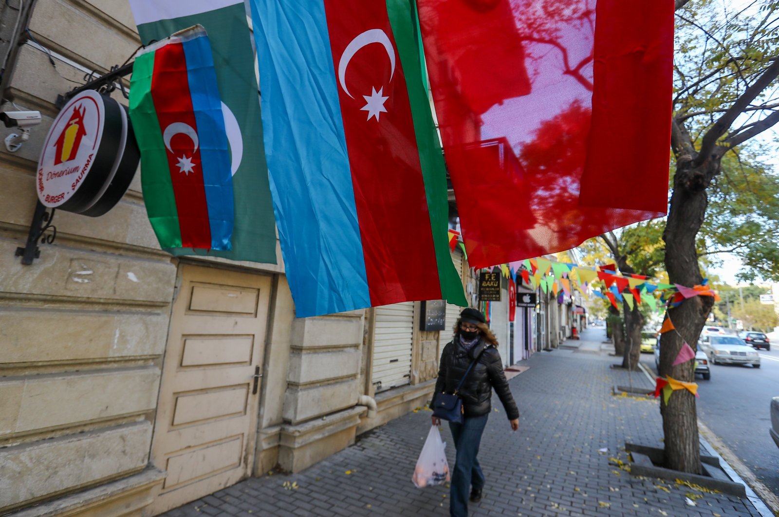 A woman walks under the flags of Azerbaijan and Turkey, which decorate the street in Baku, Azerbaijan, Nov. 28, 2020. (Photo by Getty Images)