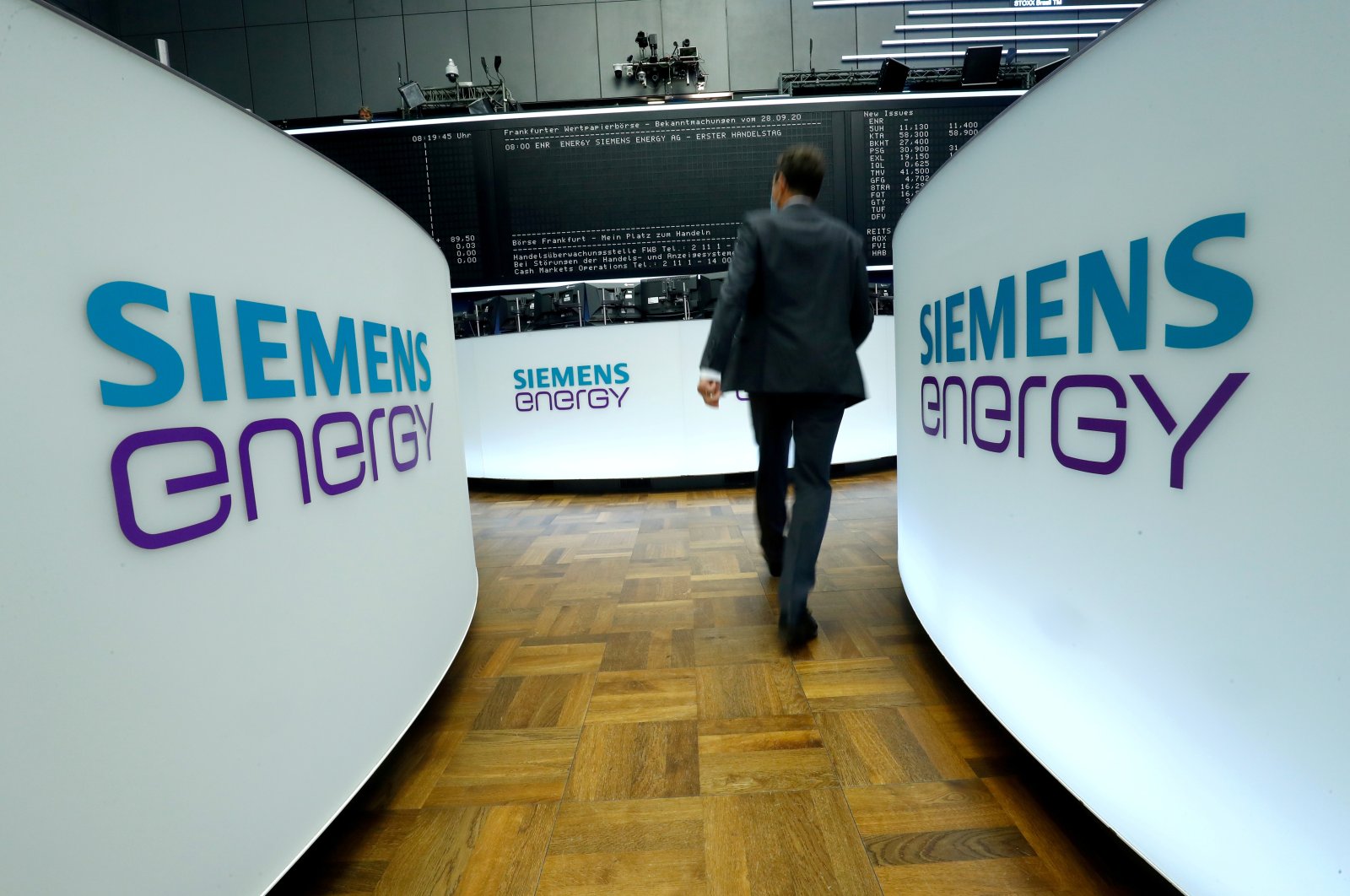 A trader walks next to Siemens Energy AG logos during Siemens Energy's initial public offering (IPO) at the Frankfurt Stock Exchange in Frankfurt, Germany, Sept., 28, 2020. (Reuters Photo)