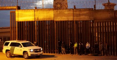 Migrants are detained by a U.S. Border Patrol agent as they turn themselves in to request asylum, after crossing into El Paso, Texas, U.S., as seen from Ciudad Juarez, Mexico on Feb. 2, 2021. (Reuters Photo)