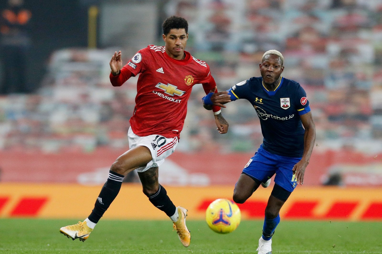 Manchester United's Marcus Rashford (L) goes past Southampton's Moussa Djenepo during their Premier League match, Old Trafford, Manchester, Feb. 2, 2021.