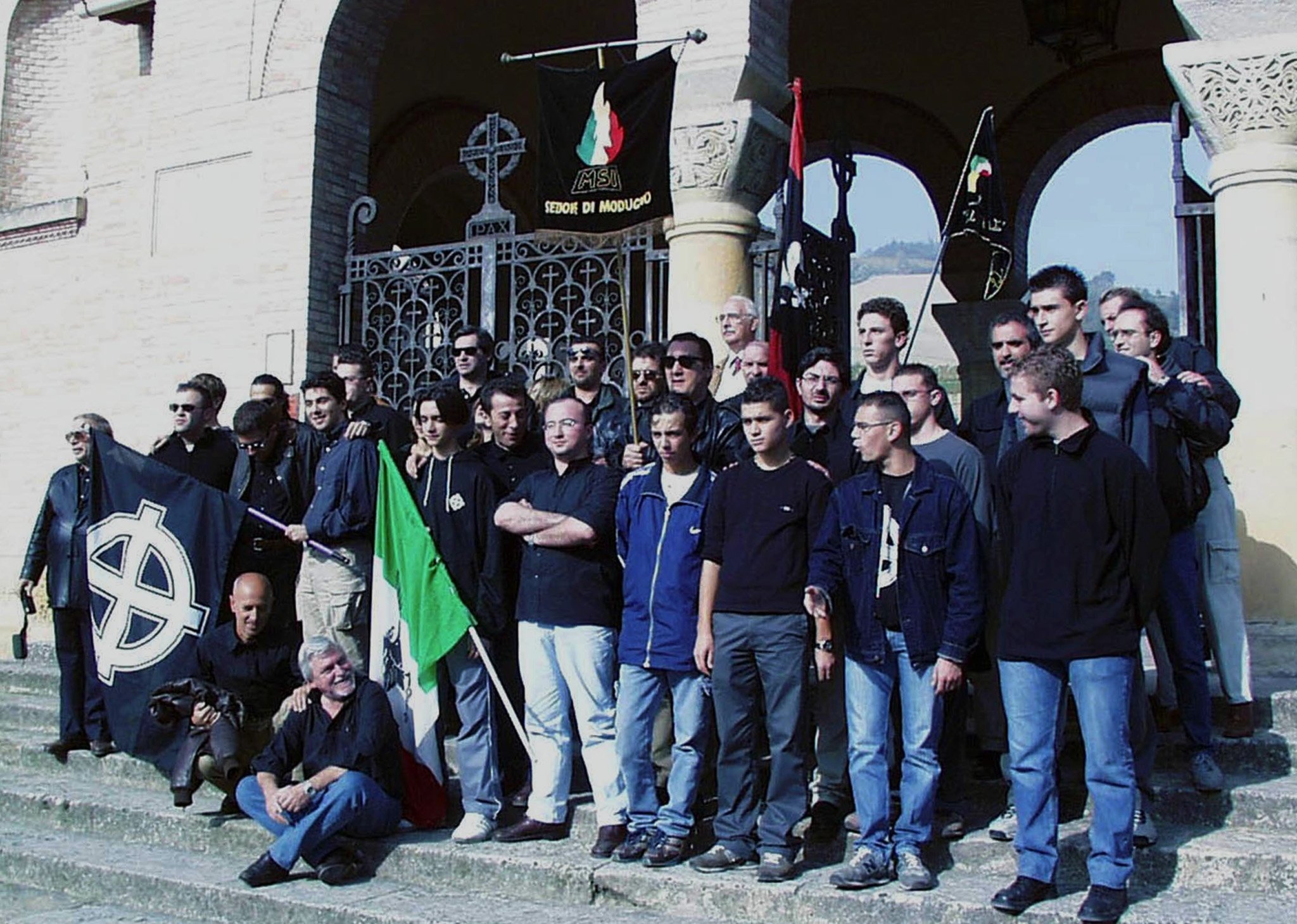 A group of far-right youth poses in front of the San Cassiano cemetery where Benito Mussolini is buried, on the occasion of the 78th "Marcia su Roma," in Predappio, Italy, Oct. 29, 2000. (AP Photo)