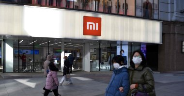 In this file photo, people walk past a Xiaomi store in Beijing, China, Jan. 15, 2021. (AFP Photo)