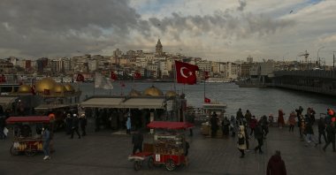 People wearing masks to help protect against the spread of the coronavirus walk near Galata Bridge in Istanbul, Turkey, Jan. 29, 2021. (AP Photo)
