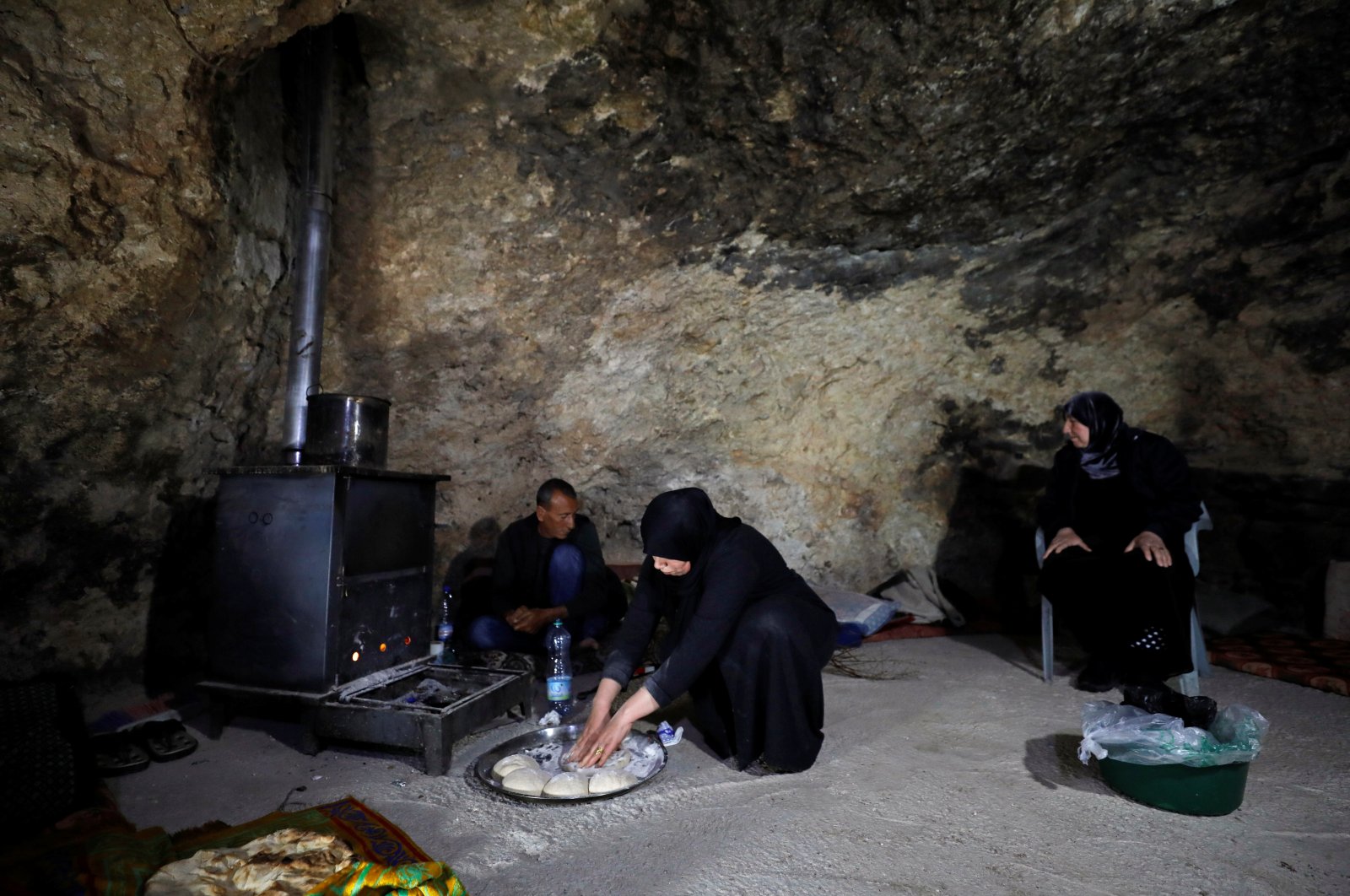 A Palestinian woman prepares dough for bread in a hillside cave, near Hebron, in the Israeli-occupied West Bank, Palestine, Jan. 28, 2021. (Reuters Photo)