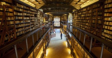 A woman wears a protective mask against the coronavirus as she stands in the Duke Humphrey’s Library at the Bodleian Libraries, in Oxford, Britain, Aug. 25, 2020. (Photo by Getty Images)