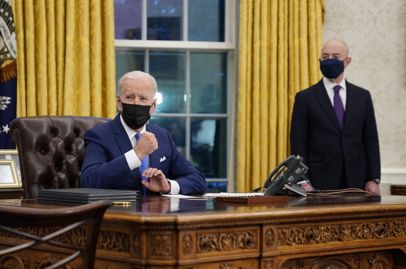 President Joe Biden gestures as he delivers remarks on immigration as the Secretary of Homeland Security Alejandro Mayorkas listens on the right, Oval Office, White House, Washington, Feb. 2, 2021. (AP Photo)