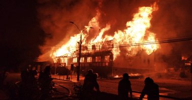 The building of the Municipality of Panguipulli set on fire by protesters during a demonstration over the murder of a street artist by the local police, Feb. 5, 2021. (AFP Photo)