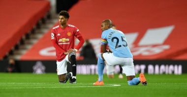 Manchester United's Marcus Rashford (L) and Manchester City's Fernandinho take a knee in support of the Black Lives Matter movement before the English Premier League football match between Manchester United and Manchester City, at the Old Trafford stadium in Manchester, England, Dec. 12, 2020. (AFP Photo) 