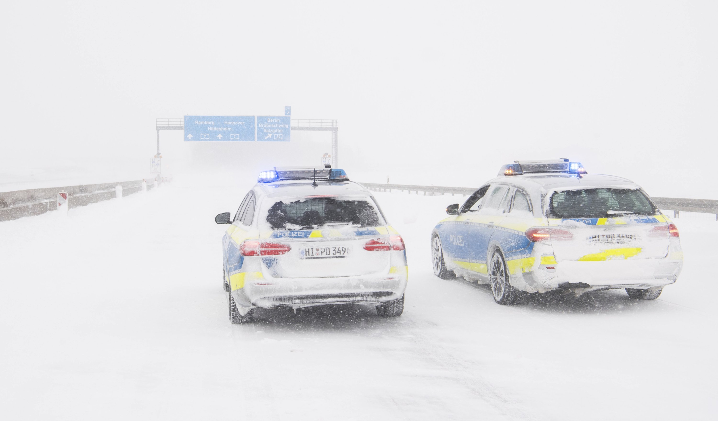 Police vehicles stand on the closed A7 motorway at the Salzgitter interchange in Bockenem, Germany, Sunday, Feb. 7, 2021. (Julian Stratenschulte/dpa via AP)