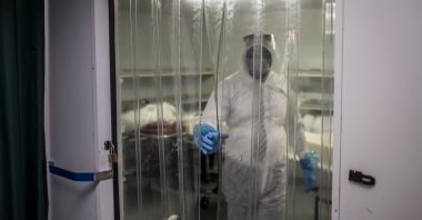An undertaker emerges from a cold storage room where the remains of COVID-19 patients are stored, at the AVBOB funeral house in Soweto, South Africa, July 21, 2020. (AFP Photo)