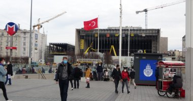 People wearing masks walk in Istanbul's Taksim Square, Turkey, Feb. 1, 2021. (IHA Photo)