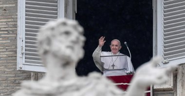 Pope Francis waves from the window of the Apostolic Palace overlooking St. Peter's Square during the weekly Angelus prayer on Feb. 7, 2021 in the Vatican (AFP)