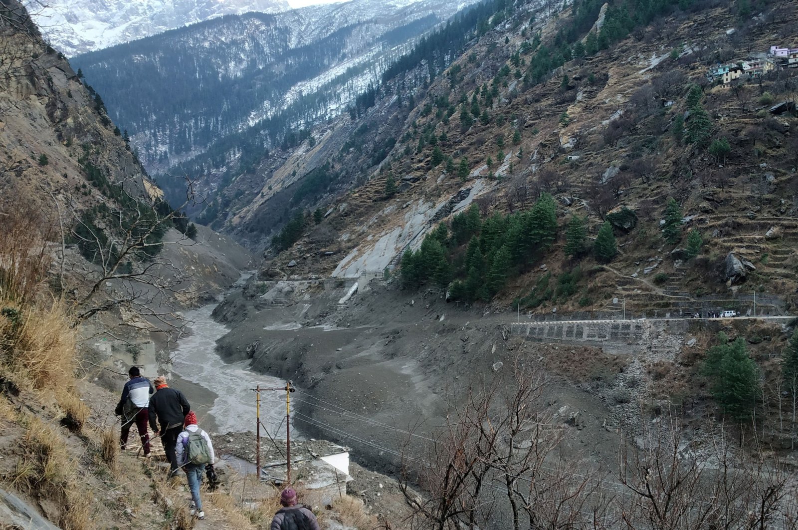 People walk past a destroyed dam after a Himalayan glacier broke and crashed at Raini Chak Lata village in the Chamoli district, in the northern state of Uttarakhand, India, Feb. 7, 2021. (Reuters Photo)