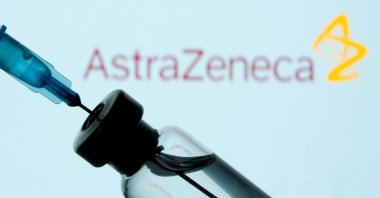 A vial and syringe are seen in front of an AstraZeneca logo in the illustration created on Jan. 11, 2021. (REUTERS Photo)