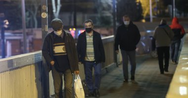 People wearing protective masks walk on an overpass, in Istanbul, Turkey, Feb. 8, 2021. (AA Photo)