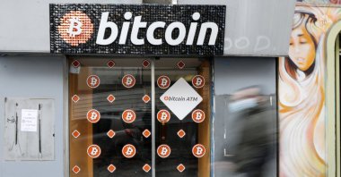 A man wearing a protective mask walks past a Bitcoin digital currency ATM shop in Marseille, France, Feb. 7, 2021. (Reuters Photo)