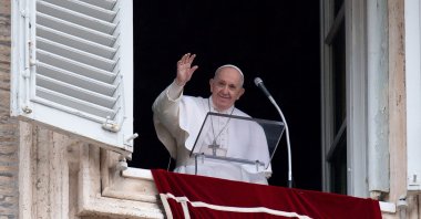 Pope Francis waves from the window of the apostolic palace overlooking St. Peter's Square during the weekly Angelus prayer in the Vatican, during the COVID-19 pandemic, Feb. 7, 2021. (AFP)