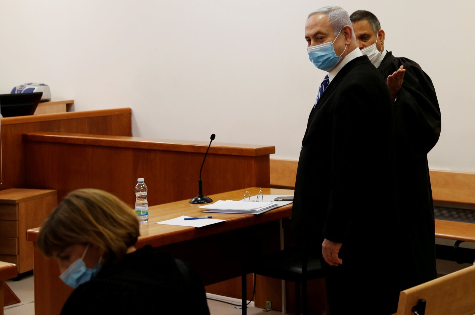 Israeli Prime Minister Benjamin Netanyahu, wearing a mask, stands inside the courtroom as his corruption trial opens at the Jerusalem District Court, Jerusalem, May 24, 2020. (Reuters Photo)