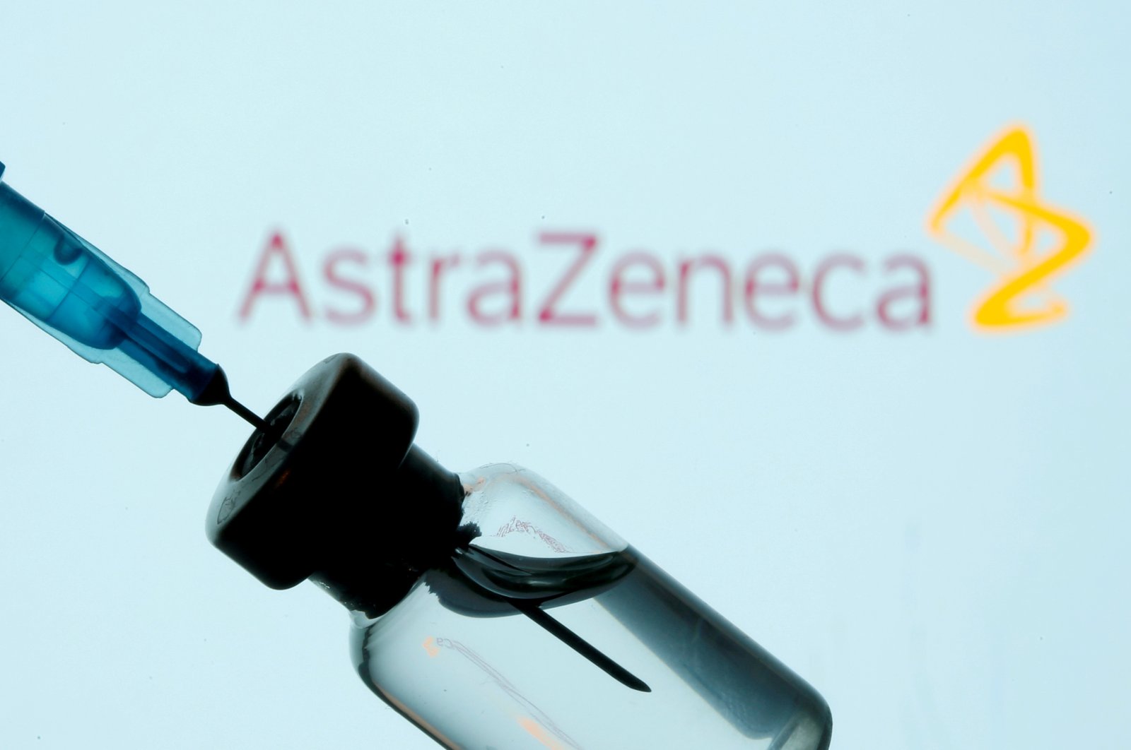 A vial and syringe are seen in front of an AstraZeneca logo in the illustration created on Jan. 11, 2021. (REUTERS Photo)