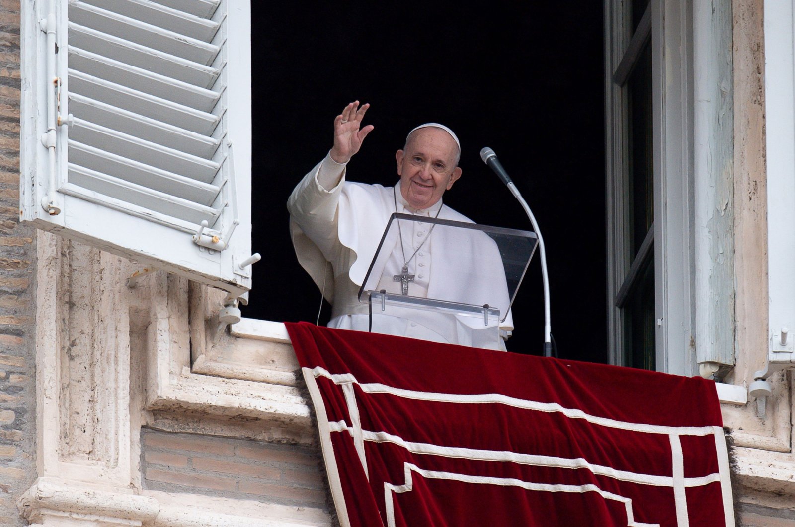 Pope Francis waves from the window of the apostolic palace overlooking St. Peter's Square during the weekly Angelus prayer in the Vatican, during the COVID-19 pandemic, Feb. 7, 2021. (AFP)