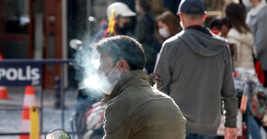 A man wearing a protective mask smokes on a street in Kırklareli, northwestern Turkey, Nov. 13, 2020. (AA PHOTO) 