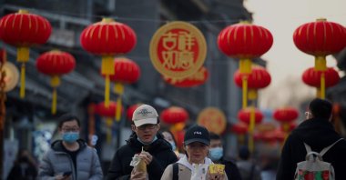 People walk under traditional Chinese lanterns on display ahead of the biggest holiday of the year, the Lunar New Year, Beijing, Feb. 9, 2021. (AFP Photo)