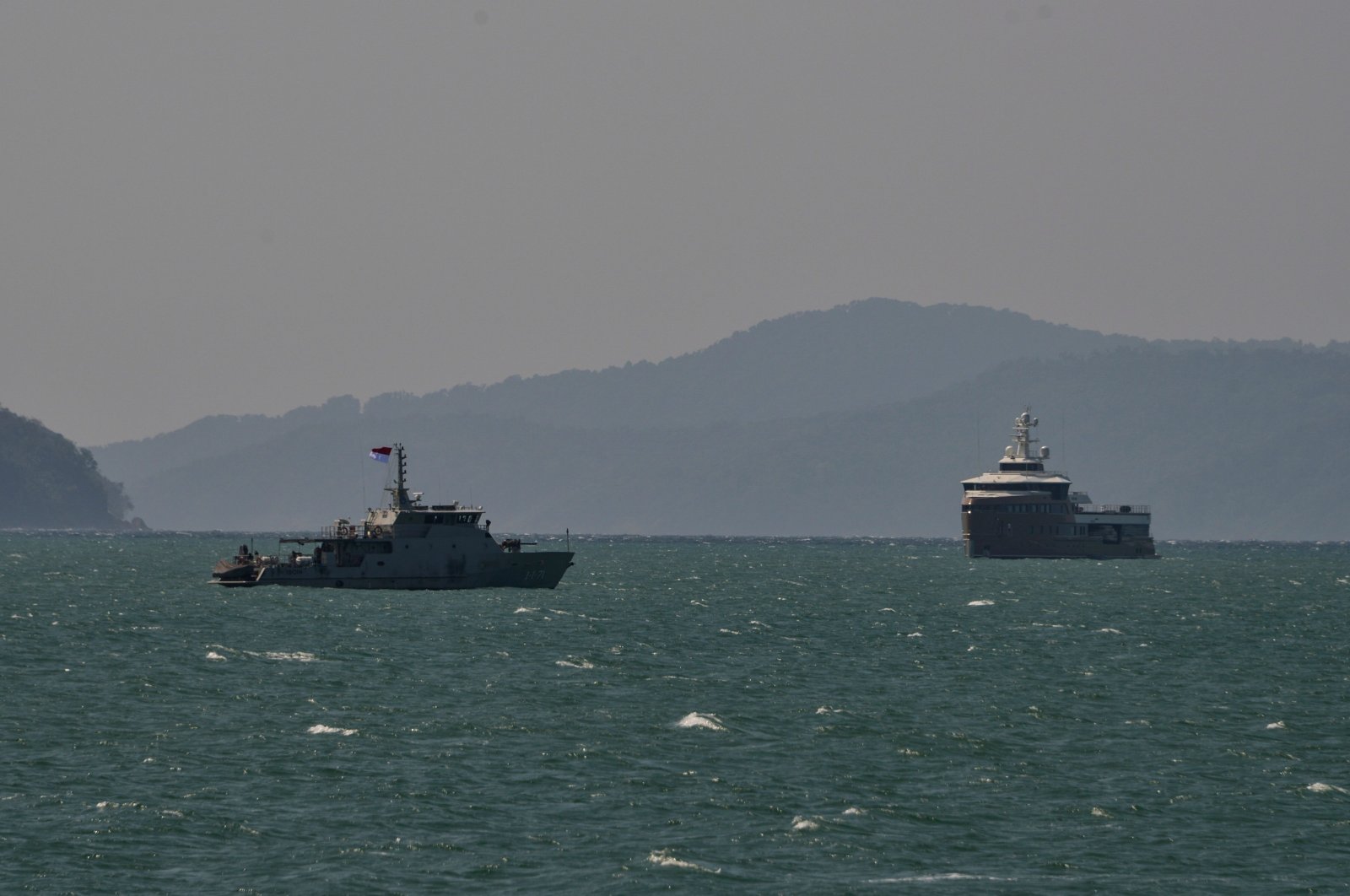 An Indonesian naval ship (L) escorts the Russian superyacht "La Datcha George Town" near the coast of Aceh province, in Banda Aceh, Indonesia, Feb. 8, 2021. ( AFP Photo)