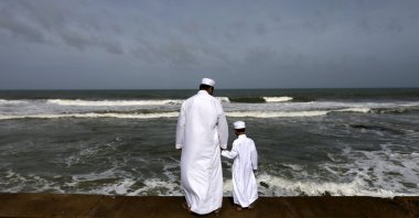 A Sri Lankan Muslim father and son stand in front of the sea during morning prayers of Eid al-Fitr celebrations marking the end of Ramadan, in Colombo, July 18, 2015. (Reuters Photo)