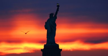 The sun rises behind the Statue of Liberty in New York City as seen from Jersey City, New Jersey, the U.S., Feb. 6, 2021. (Photo by Getty Images)