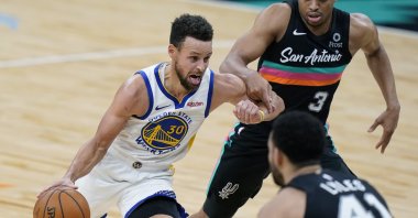 Golden State Warriors guard Stephen Curry (L) drives past San Antonio Spurs forward Keldon Johnson (R) during an NBA game in San Antonio, Tuesday, Feb. 9, 2021. (AP Photo)
