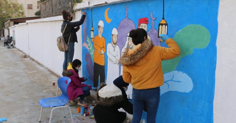 A group of young people decorates the walls of northern Syria's Afrin town with drawings, Feb. 10, 2021. (AA Photo)