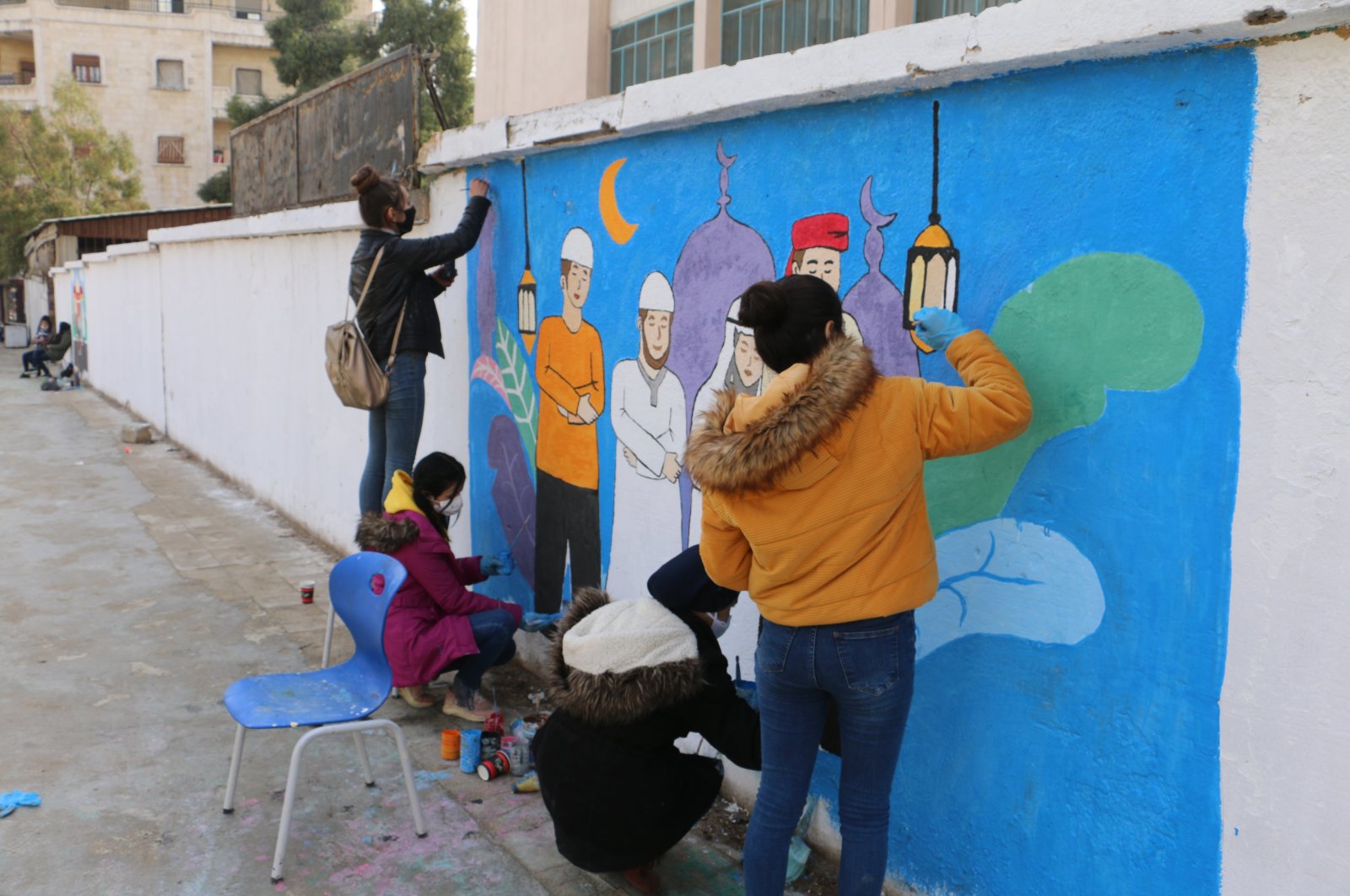 A group of young people decorates the walls of northern Syria's Afrin town with drawings, Feb. 10, 2021. (AA Photo)