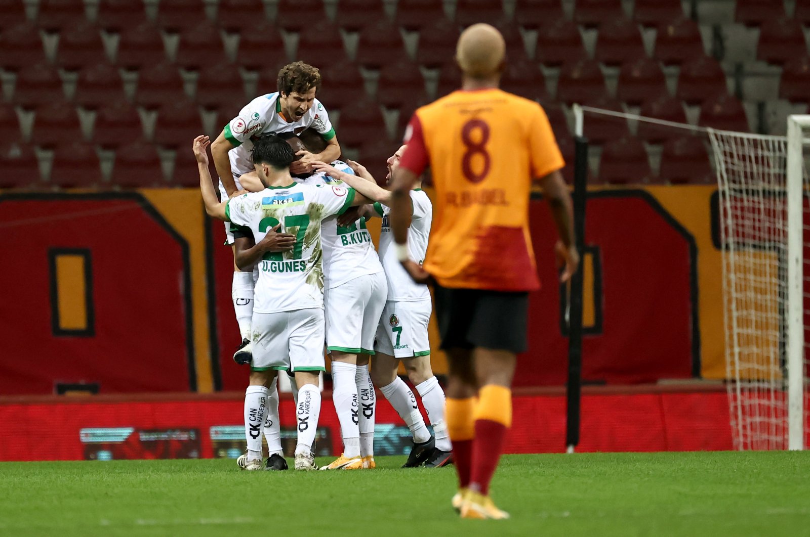 Alanyaspor players celebrate after a goal while Galatasaray's Ryan Babel walks during the Turkish Cup match at the Turk Telekom Stadium in Istanbul on Feb. 10, 2021 (AA Photo)