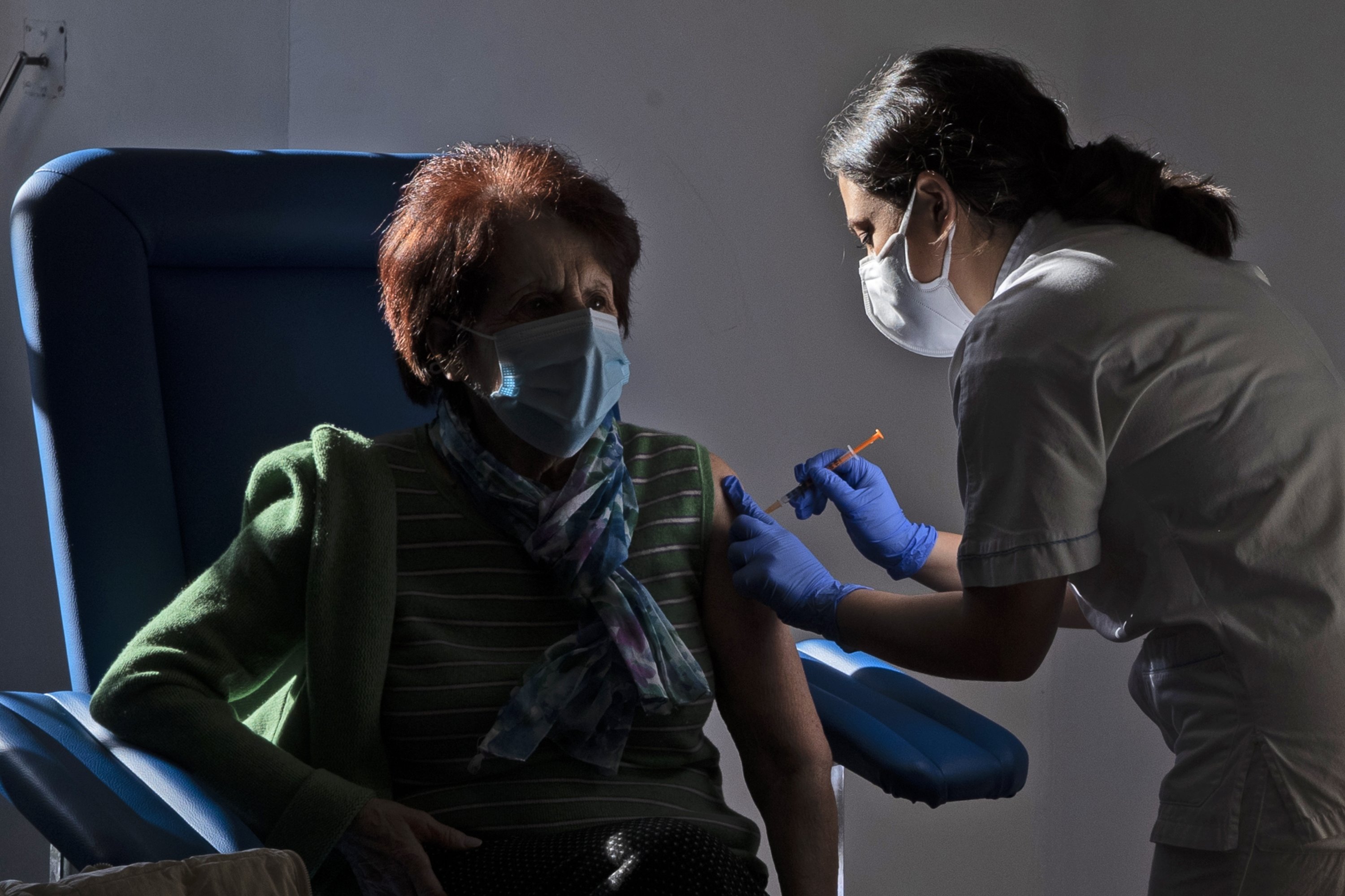 A medical staff member administers a dose of the Pfizer-BioNTech vaccine to an over 80-year-old, in the Santa Maria della Pieta hospital in Rome, Italy, Feb. 8, 2021. (AP Photo)