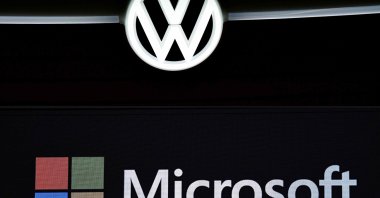 This combination of pictures created on Feb. 11, 2021, shows (on top) the Volkswagen (VW) logo pictured, on Feb. 27, 2019, in Berlin, and (on bottom) the Microsoft logo during a presentation at the Mobile World Congress (MWC) in Barcelona on Feb. 24, 2019. (AFP Photo)