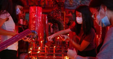 Worshippers wearing protective masks light incense sticks as they pray during Chinese Lunar New Year's eve at a temple in Jakarta, Indonesia, Feb. 11, 2021. (Reuters Photo)