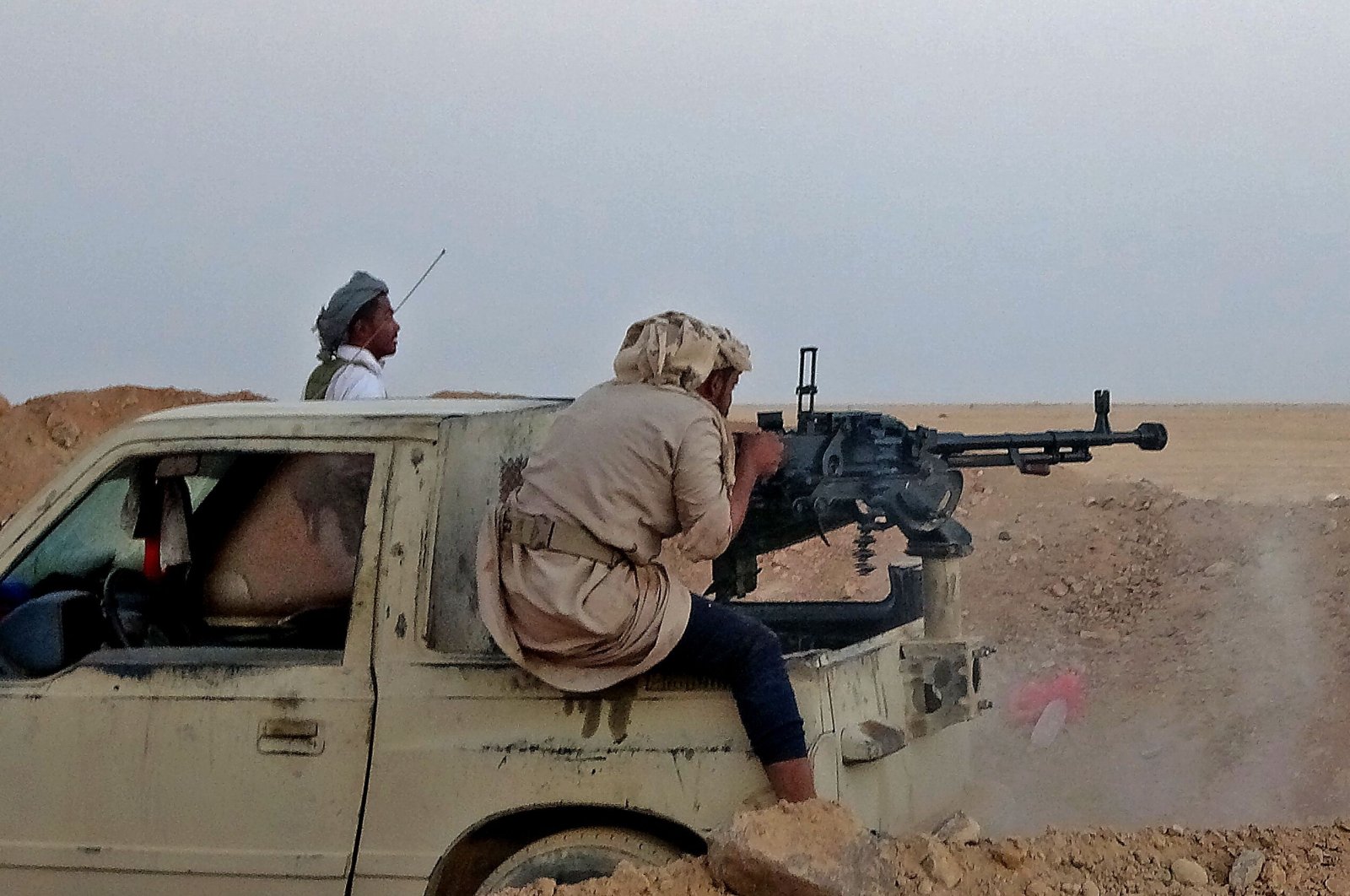 A combatant mans a heavy machine gun as forces loyal to Yemen's Saudi-backed government clash with Houthi fighters around the strategic "Mas Camp" military base, in al-Jadaan area, Yemen, Nov. 22, 2020. (AFP Photo)
