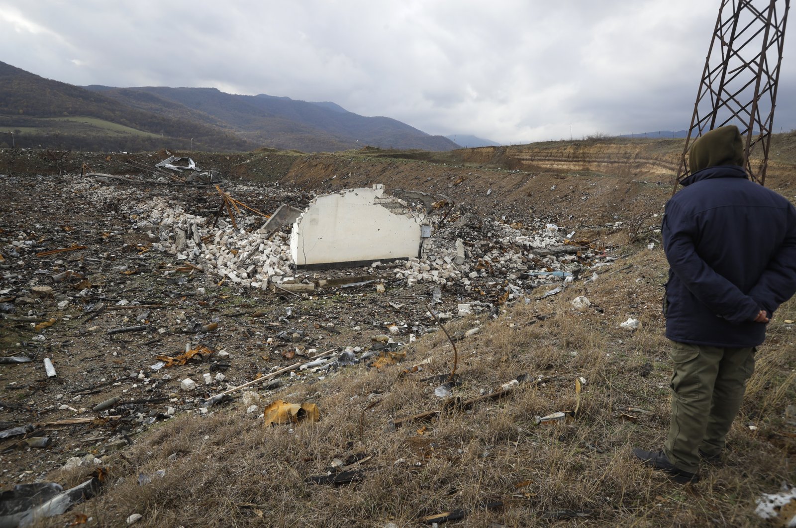 A member of a survey team from the Halo Trust mine-clearing organization looks on at a damaged ammunition store near the outskirts of the capital Stepanakert (Khankendi) of Nagorno-Karabakh, Azerbaijan, Nov. 23, 2020. (AP File Photo)