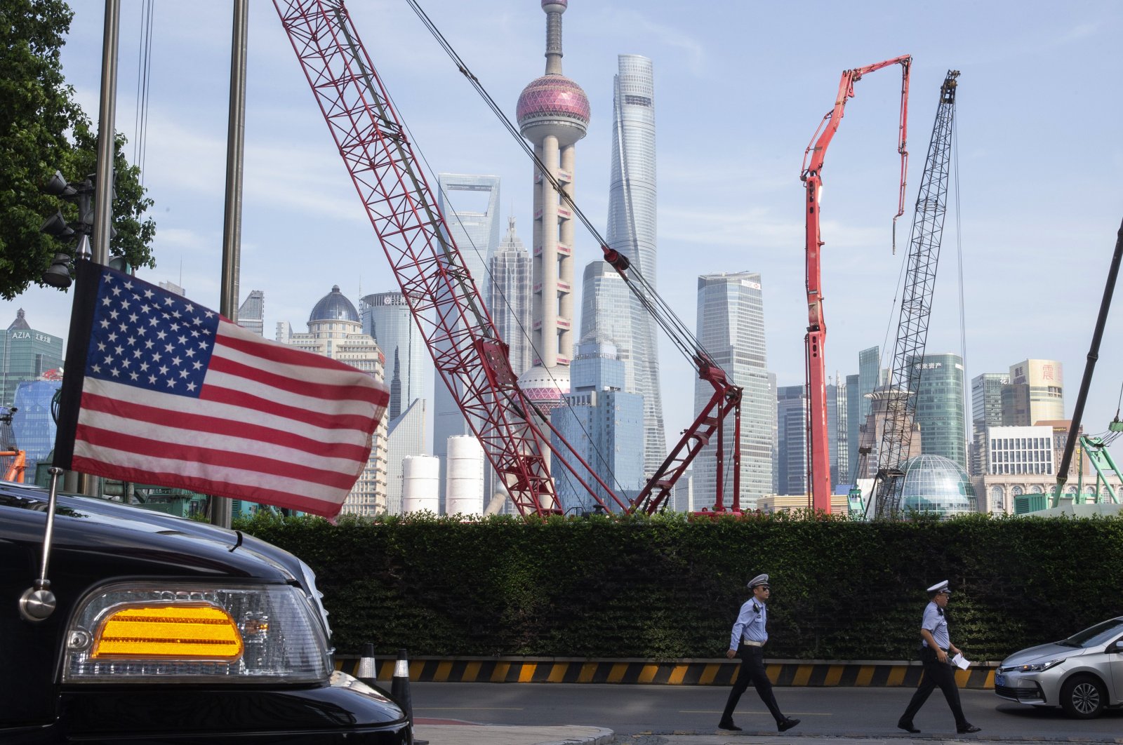 Chinese police officers walk by a U.S. flag on an embassy car outside a hotel in Shanghai, China, July 30, 2019. (AP Photo)